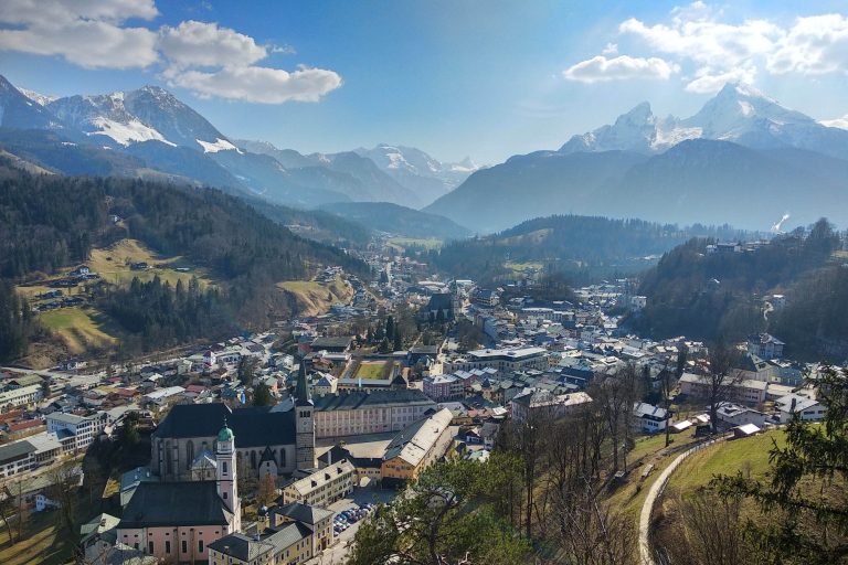 Aussichtspunkt Lockstein Berchtesgaden Panorama von Berchtesgaden in den Bergen mit grünen Tälern und schneebedeckten Gipfeln, mit Watzmann im Hintergrund.