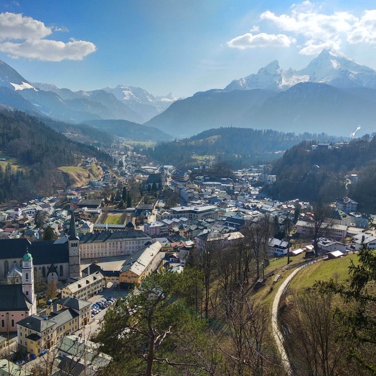 Panorama von Berchtesgaden in den Bergen mit grünen Tälern und schneebedeckten Gipfeln, mit Watzmann im Hintergrund. 